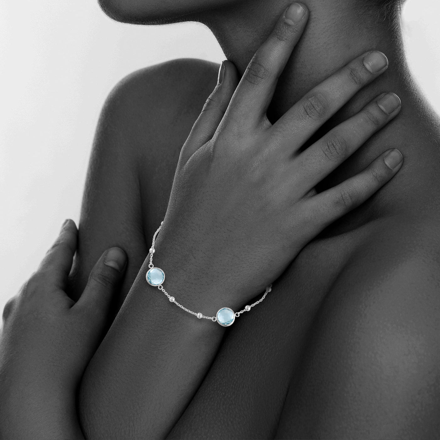 Sterling Silver Bezel Bracelet With Small Silver Stations And Blue Topaz Round Gemstones